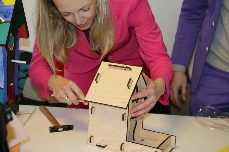 Sandra Yvonne Stieger, Geschäftsführerin der MMKT, baut ein Vogelhaus zusammen.