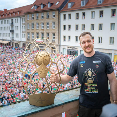 SCM Spieler Christian O'Sullivan mit Pokal auf dem Magdeburger Rathausbalkon