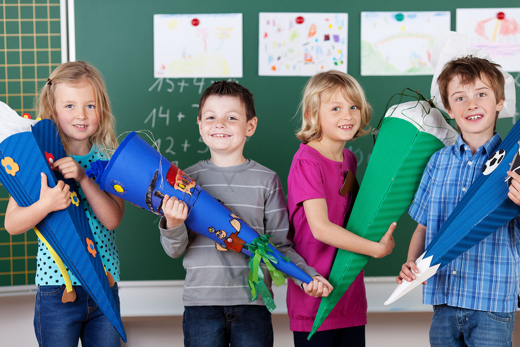 Kinder mit Zuckertüten zur Einschulung vor einer Tafel © contrastwerkstatt - Fotolia