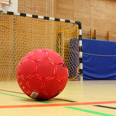 Handball vor einem Tor in einer Sporthalle