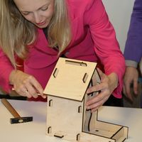 Sandra Yvonne Stieger, Geschäftsführerin der MMKT, baut ein Vogelhaus zusammen.