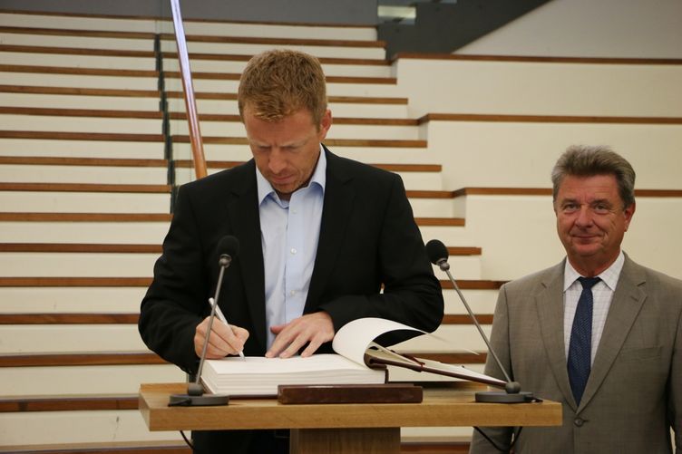 Trainer Bernd Berkhahn trägt sich in das Goldene Buch der Landeshauptstadt ein. 