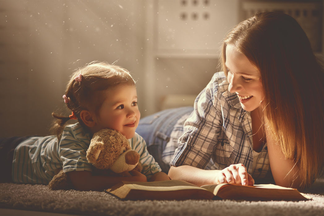 Frau und Kind mit Kuscheltier lesend ber einem Buch © Jenko Ataman - Fotolia