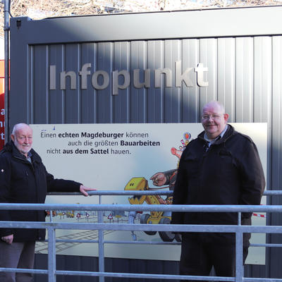 Die beiden Mitarbeiter, Herr Rode und Herr Krumm, vor dem Infocontainer.