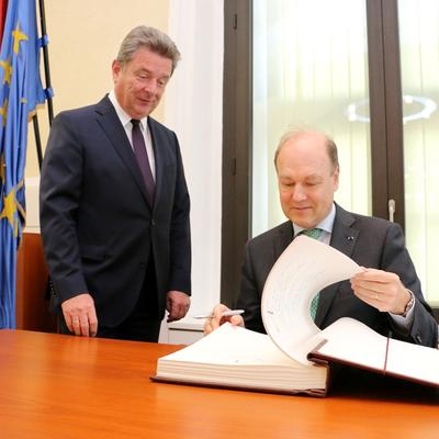 Oberbürgermeister Dr. Lutz Trümper und der Botschafter des Königreiches Belgien, S.E. Baron Willem Van de Voorde, begutachten das Goldene Buch der Landeshauptstadt.