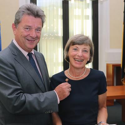 Oberbürgermeister Dr. Lutz Trümper steckt Sabine Koch die Ehrennadel an. 