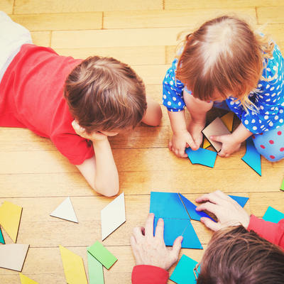 teacher and kids playing with geometric shapes