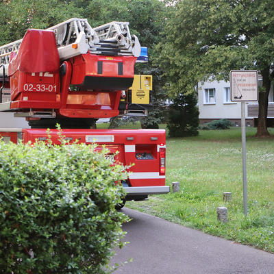 Drehleiterwagen im Wohngebiet mit Schild "Rettungsweg"