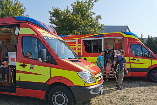 Bild vergrößern: Besucher schauen sich zwei Rettungsfahrzeuge an