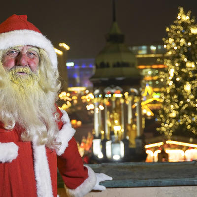 Weihnachtsmann auf dem Rathausbalkon, Hintergrund: Weihnachtsmarktbeleuchtung