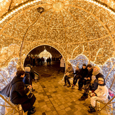 Passanten sitzen in der beleuchteten Weihnachtskugel der Lichterwelt