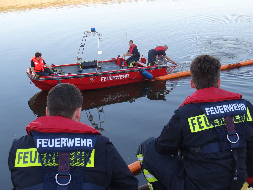 Rettungsschnellboot mit Uferunterstützung bei Ausbringen Ölsperre