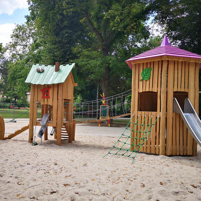 Spielhaus mit Rutsche und Kletternetz auf dem Spielplatz Schneidersgarten