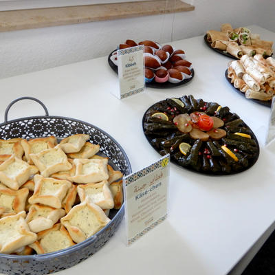 Auswahl internationaler Speisen wie Baklava und Kibbeh auf einem Tisch
