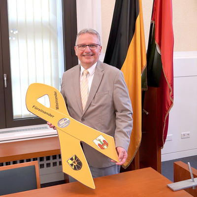 Magdeburgs Bürgermeister Klaus Zimmermann mit der Gelben Schleife der Bundeswehr