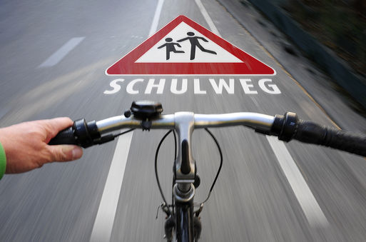 Radfahrer auf einem Radweg mit dem Hinweisschild "Achtung Kinder"