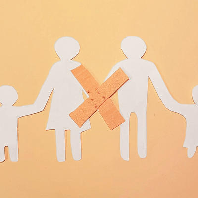 Papierfigur: Eltern und 2 Kindern Hand in Hand mit einem Pflaster als Verbindung