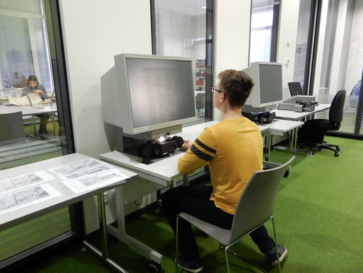 Bild vergrößern: Schüler recherchiert am Mikrofilm-Lesegerät.