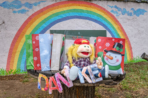 Papierkirlande mit buntem Danke-Schriftzug vor einem Regenbogen