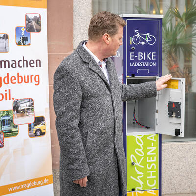 Magdeburgs Beigeordneter Rehbaum zeigt die neue E-Bike-Ladestation