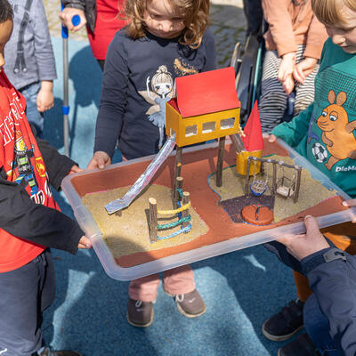 Die Kinder der Integrativen Kita »Kuschelhaus« mit einem Spielplatzmodell.