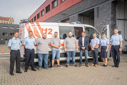 Johanniter Magdeburg und Feuerwehr-Angehörige vor dem neuen Einsatzleitwagen