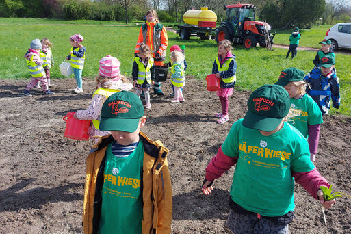 Bild vergrößern: Kinder der Kita Fliedergrund helfen beim Anlegen eine Blühwiese im Floraparkgarten_1