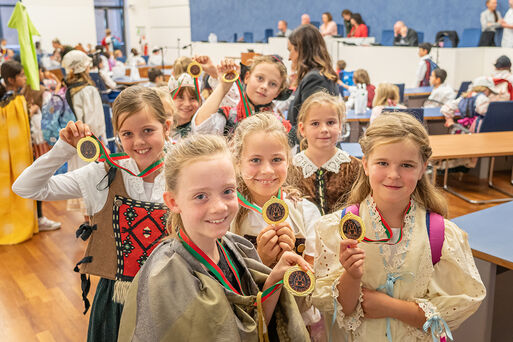 Kinder zeigen freudig Zertifikate in Form einer Medaille »Magdeburger Recht«