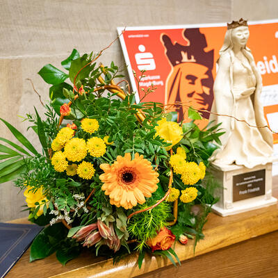 Adelheid-Preis-Statue, Blumenstrauß und Dotationsscheck